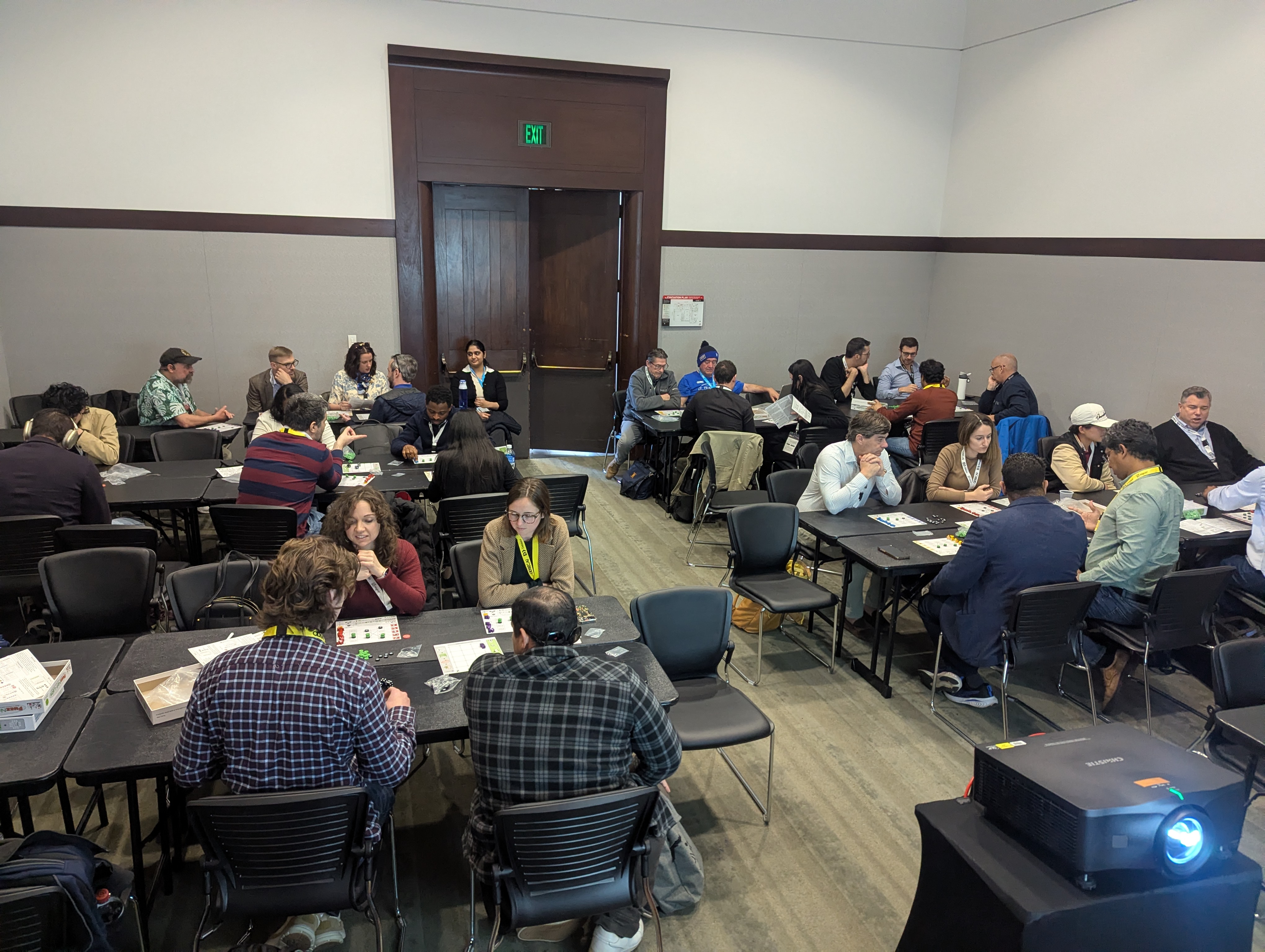 A full room of participants playing FuzzNet Labs in person at tables