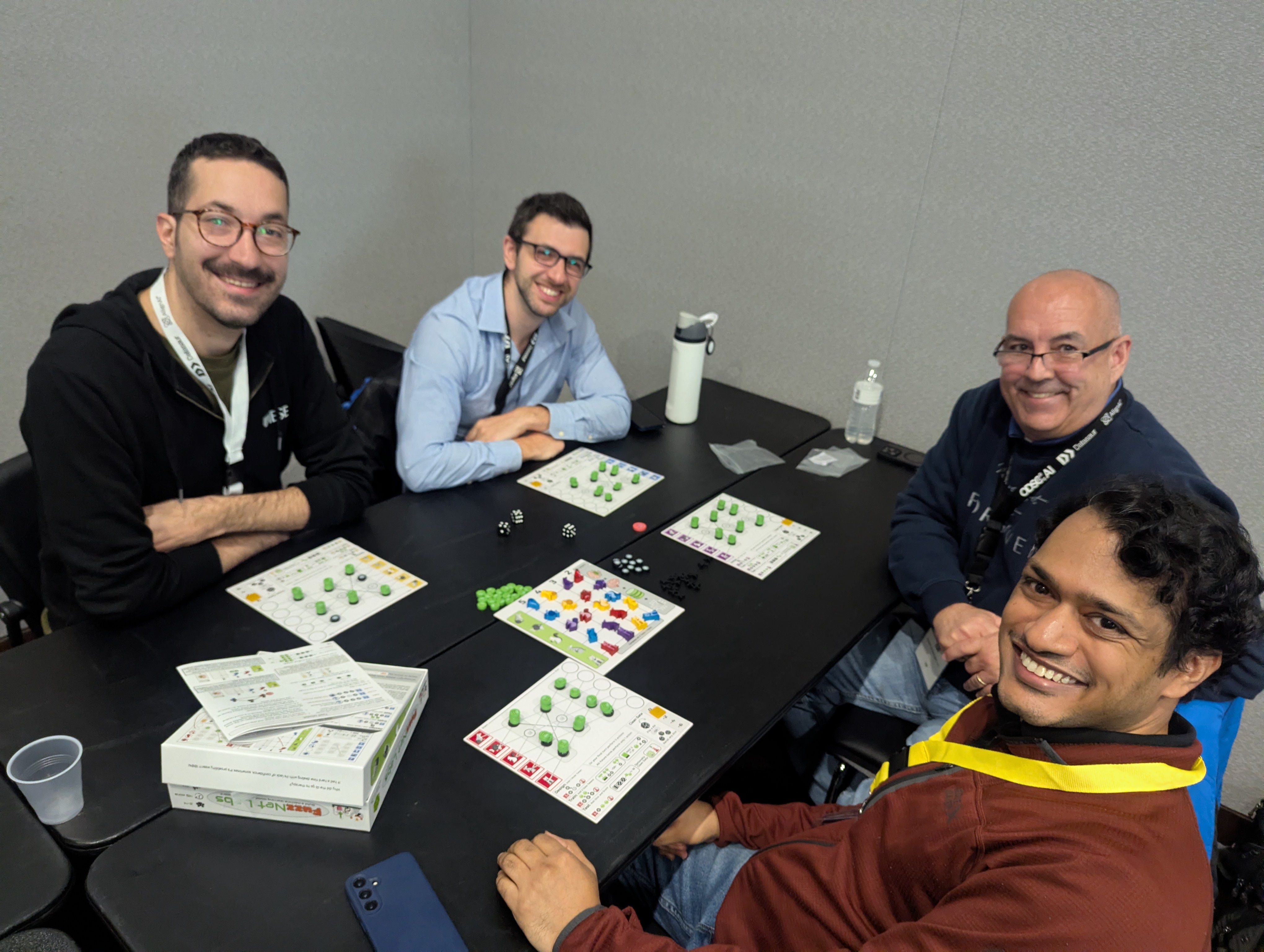 Participants engaged in a FuzzNet Labs game across two tables